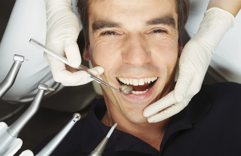 Uśmiechnięty mężczyzna u dentysty